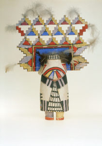 Squat doll with large headdress painted in primary colors