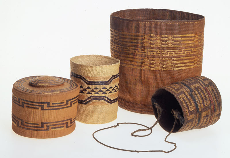 four uniquely shaped woven baskets in brown and tan colors
