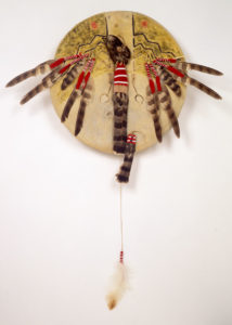 Buffalo hide shield, painted, with hanging feather details